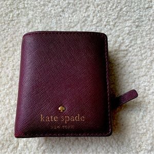 Kate Spade folding leather wallet in plum purple.